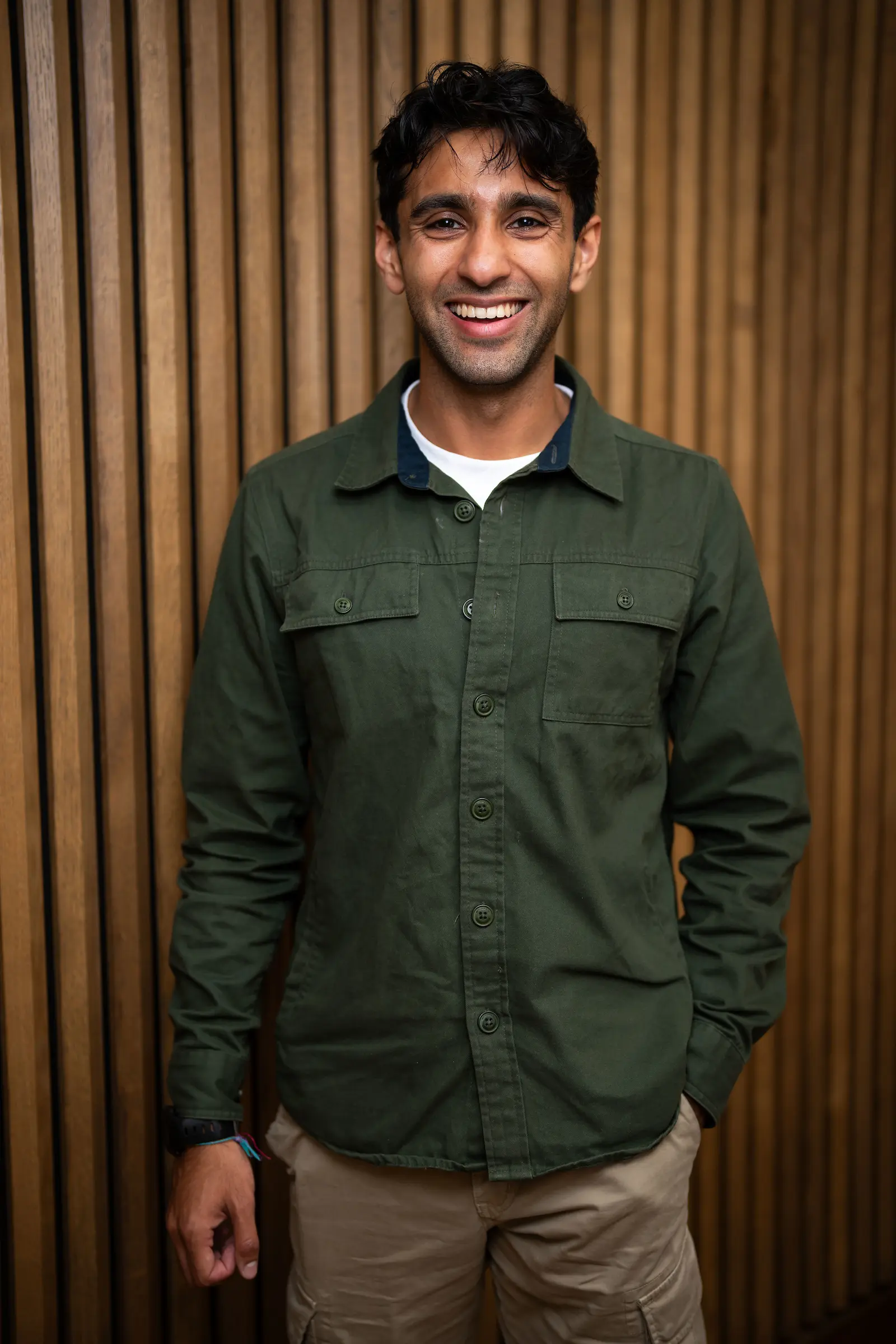 Seth Daood. A man with short dark hair wearing a white t-shirt with green shirt over the top.