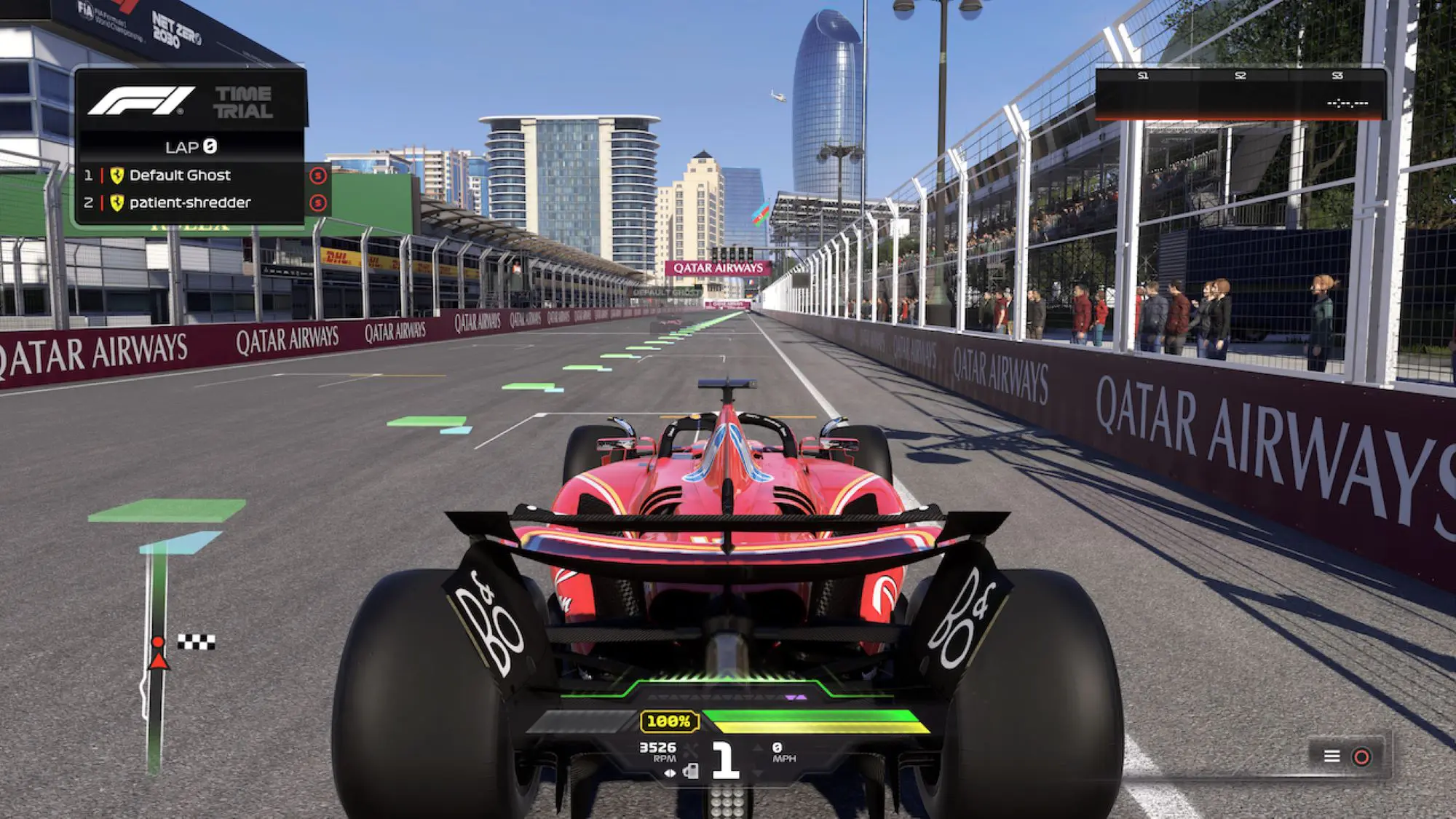 A red racing car with B&O hub caps on a racetrack with high-rise glass buildings in the background.