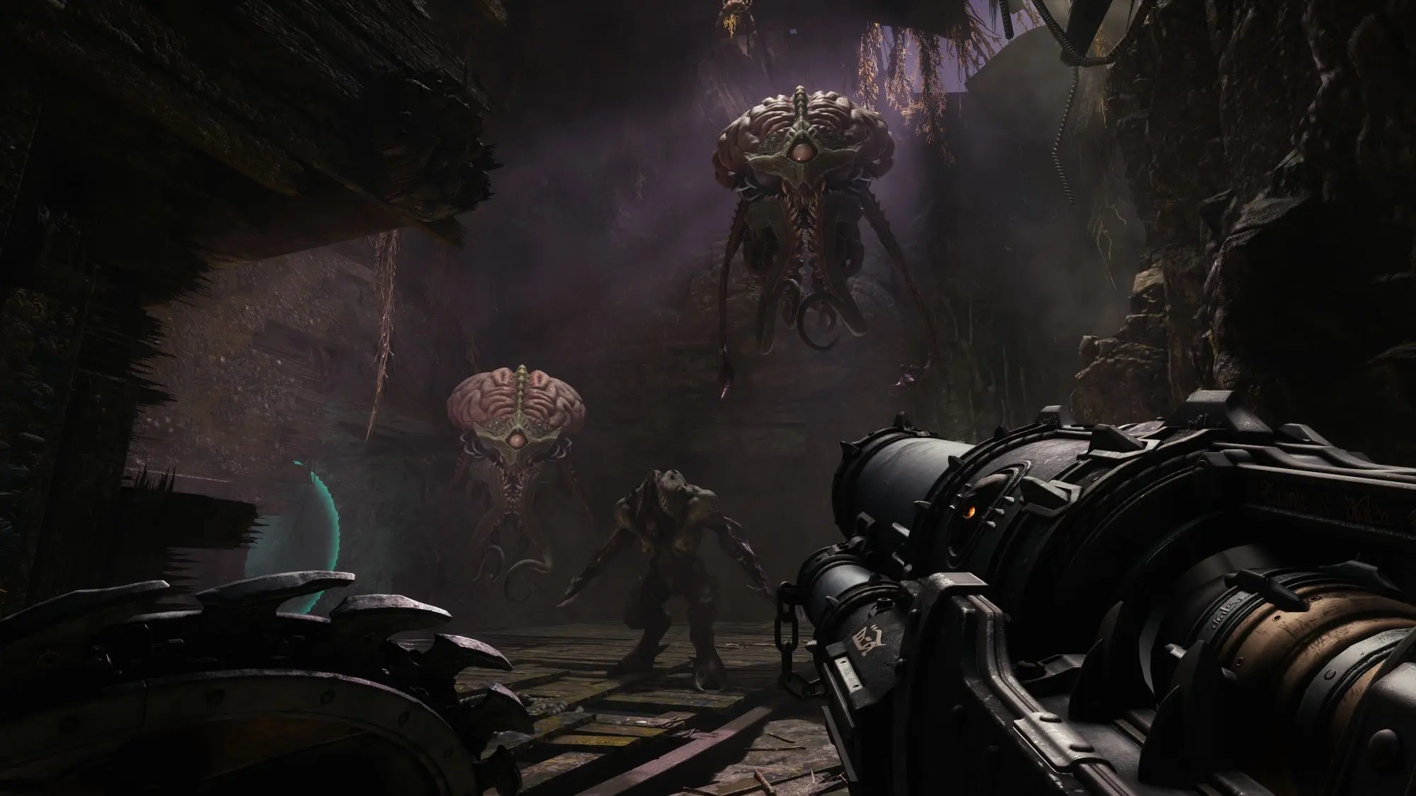 A still from the game DOOM The Dark Ages. A dark cave like room with floating brain type figures.