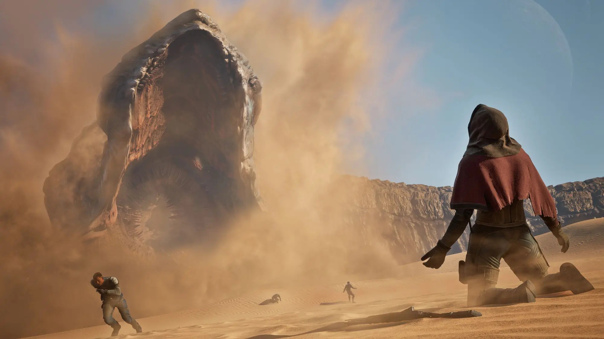 A still from the game Dune Awakening. A desertscape with a giant sandworm emerging from the ground and a figure kneeling before it.