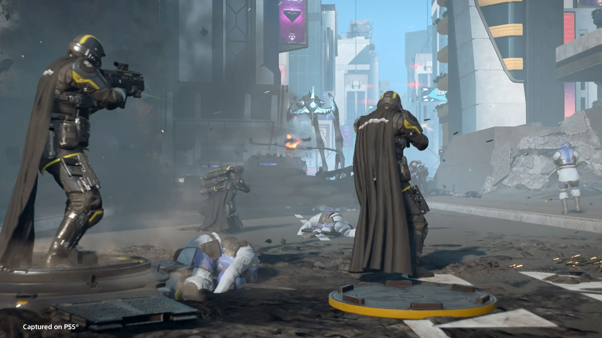 A short from the game Helldivers 2. Three military style figure in black, with black capes, shooting at a glowing robotic like object in the distance.